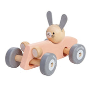A wooden toy racing car with a bunny figure sitting inside. The car is pink and gray, with four grey wheels.